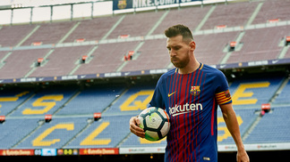 Sem torcida em dia caótico, líder 100% Barcelona vence Las Palmas com dois de Messi Messi carrega a bola nos braços durante partida com Las Palmas em um vazio Camp Nou