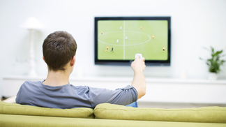 Dinheiro da TV ajuda, mas conta menos para o Flamengo do que para o resto do futebol brasileiro Homem assiste futebol na televisão TV