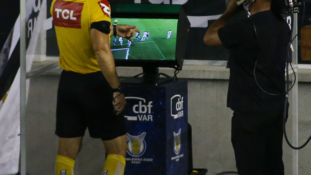 Árbitro checa o VAR durante jogo entre Santos e Vasco, pelo Brasileirão