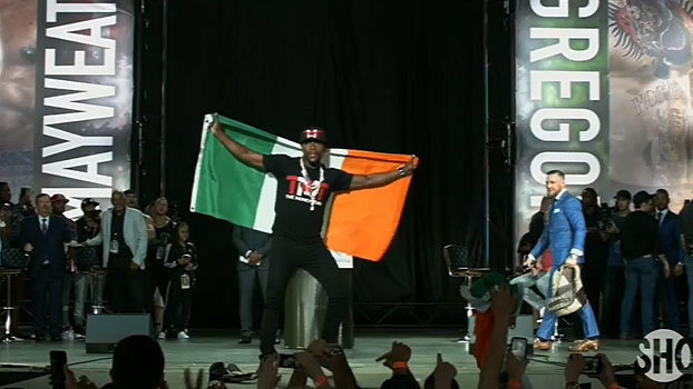 Vai longe! Mayweather provoca com bandeira da Irlanda, e McGregor responde 'roubando' mochila de boxeador Vai longe! Mayweather provoca com bandeira da Irlanda, e McGregor responde 'roubando' mochila de boxeador
